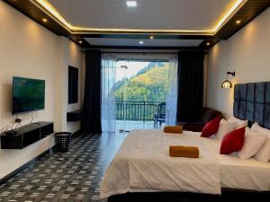 a bedroom with a large bed and a balcony at Paraiso Guest House in Ella