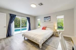 a bedroom with a bed and two windows at 2 Mi to Deerfield Beach Home with Outdoor Oasis! in Deerfield Beach +18 photos