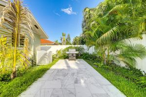 a bench sitting on a walkway next to a building at 2 Mi to Deerfield Beach Home with Outdoor Oasis! in Deerfield Beach