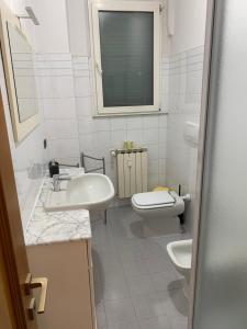 une salle de bains blanche avec toilettes et lavabo dans l'établissement Hawaiian Apartment, à Florence