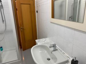 une salle de bains avec lavabo, miroir et baignoire dans l'établissement Hawaiian Apartment, à Florence