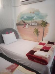 a bedroom with a bed with a painting on the wall at Nubian Life Nile View in Aswan