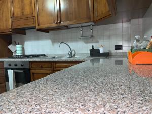 - une cuisine avec des placards en bois et un plan de travail en granit dans l'établissement Hawaiian Apartment, à Florence