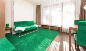 a living room with green furniture and a green rug at Residence Caddies Club in Crans-Montana