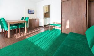 a living room with a table and green chairs at Residence Caddies Club in Crans-Montana