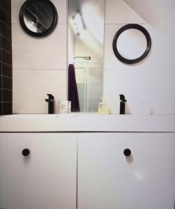 a bathroom with a white sink and a mirror at Agréable appartement derriere les arenes de Nimes in Nîmes
