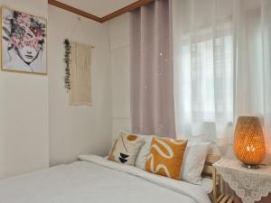 Una habitación blanca con una cama y una ventana en Happy Home Stay, en Seúl