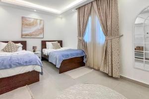 Yas IslandにあるLuxury Villaのベッド2台と窓のある寝室