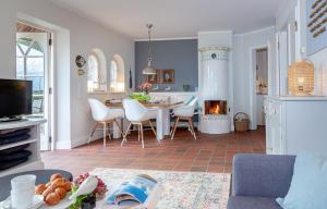 a living room with a kitchen with a table and a fireplace at Watt Hüs Munkmarsch in Munkmarsch +52 photos