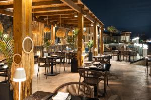 a restaurant with tables and chairs at night at Alexander Beach Hotel & Village Resort in Malia +85 photos
