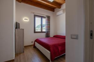 a bedroom with a red bed and a window at Villa Ginevra in Santa Ninfa +40 photos