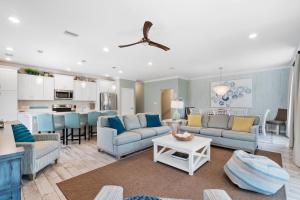 a living room with blue furniture and a kitchen at Heron's Crossing at Lost Key Golf & Beach Club in Pensacola