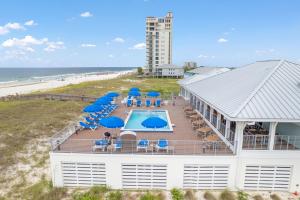 an aerial view of a building with a swimming pool and blue umbrellas at Heron's Crossing at Lost Key Golf & Beach Club in Pensacola