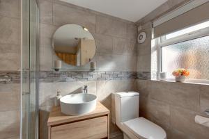 a bathroom with a sink and a toilet and a mirror at Fayette sleeps 4, 2 bedrooms, cute garden in North Creake +55 photos