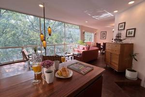 a living room with a table with food and drinks at Deco House with Park View Rooftop in Mexico City