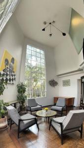 a living room with chairs and a table at Deco House with Park View Rooftop in Mexico City