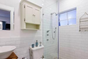 a white bathroom with a shower and a sink at Deco House with Park View Rooftop in Mexico City +42 photos