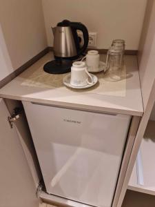 a shelf with a tea kettle and cups on it at Olympus Thea in Litochoro +11 photos