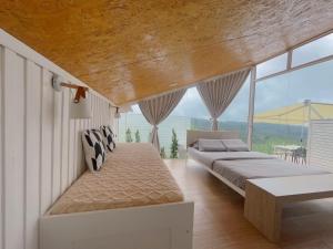 zwei Betten in einem Zimmer mit großen Fenstern in der Unterkunft Papa Garden Khaokho in Khao Kho
