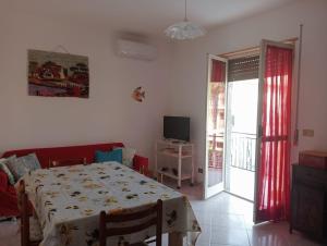 a dining room with a table and a sliding glass door at casa LULU due minuti dal mare in Ardore Marina