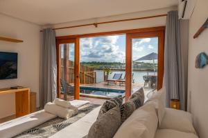 a living room with a couch and a view of the water at Bahia Soul - Lake House - Barra Grande - Península de Maraú in Barra Grande
