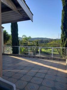 a porch of a house with a fence and trees at Fuja de tudo que está consumindo sua paz! in Atibaia