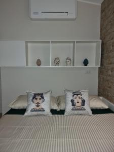 a bedroom with a bed with pillows on it at La Trinacria casa vacanze in Bronte