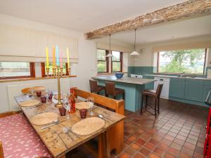 a kitchen with a wooden table and a kitchen with a counter at Oak Apple Cottage in Presteigne