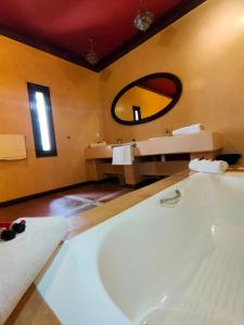 a bathroom with a tub and a sink and a mirror at Riad shéhérazade Marrakech in Marrakesh +54 photos