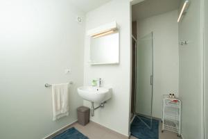 a white bathroom with a sink and a mirror at La casa di Giulio e Lina in Fossombrone +17 photos