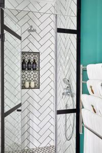 a bathroom with a shower with white tiles at Pineapple House Boutique Hotel in Cape Town