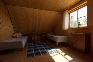 MäebeにあるVeskikivi Holiday Homeのベッドが2つと窓がある小さな部屋
