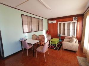a living room with a table and chairs and a couch at Gold house apartment in Vientiane