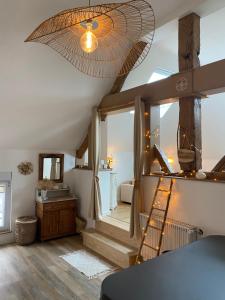 Una sala de estar con ventilador de techo y escaleras. en Au charme de la Cour, en Auxonne