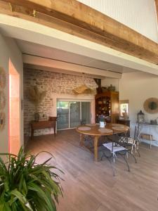Un comedor con una mesa y sillas y una pared de ladrillos. en Au charme de la Cour, en Auxonne