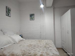 a white bedroom with a bed and a white cabinet at Departamento equipado, centrico, cochera cubierta Sarmiento265apart D13 in San Fernando del Valle de Catamarca