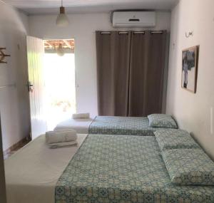 a bedroom with two beds and a window at Luar Da Barra in Barra Grande +12 photos