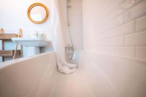 a white bathroom with a tub and a sink at Le Berry Sweet - La Douceur de vivre - Proche Gare in Châteauroux +22 photos