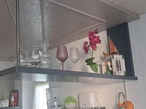 a shelf with a bunch of glass items on it at Ferienwohnung direkt am See 2 in Altmünster +13 photos