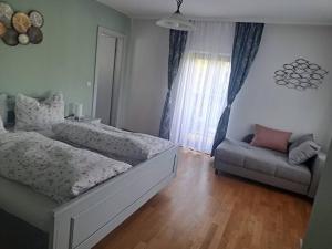 a bedroom with a bed and a couch at Ferienwohnung direkt am See 2 in Altmünster