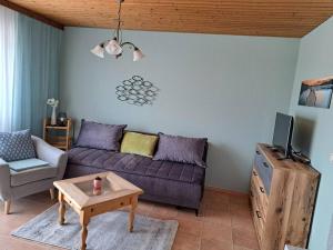 a living room with a purple couch and a table at Ferienwohnung direkt am See 2 in Altmünster