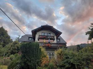 a house with a balcony and a rainbow in the sky at Ferienwohnung direkt am See 2 in Altmünster