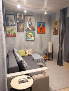a living room with a couch and pictures on the wall at City center Artmania apartments in Chişinău