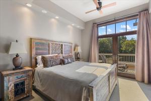 une chambre avec un grand lit et une grande fenêtre dans l'établissement Sleek Mountain Retreat - Downtown - Summer AC, à Steamboat Springs