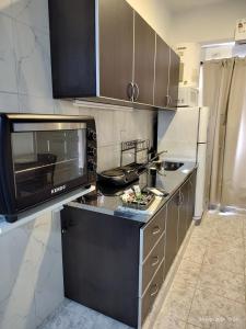 a kitchen with a microwave and a counter top at Departamento en Planta baja, centrico, cochera cubierta Sarmiento265apart D5 in San Fernando del Valle de Catamarca