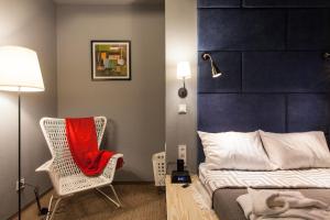 ドニプロにあるNewportのベッドルーム1室(ベッド1台、椅子、赤毛布付)