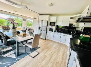 a kitchen and dining room with a table and chairs at Beausoleil SPA Villa XL-Geneva & Lake & Mountains-Wilena Home, Full Love in Chens-sur-Léman