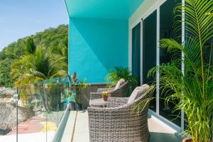 Playa Sur Paradise - Beachfront Living في سانتا كروز هواتولكو: شرفة مع كراسي من الخيزران ونباتات في منزل