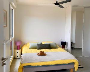 a bedroom with a bed with a hat on it at Appartement Vista Mare Sète - vues mer et étang - parking in Sète
