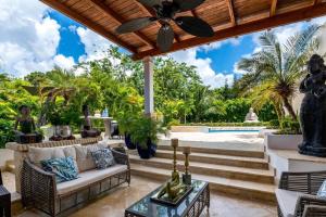 a patio with a couch and a ceiling fan at Villa Cajuiles 13, Casa de Campo in La Romana